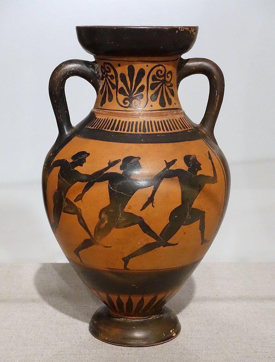 A Greek vase painted with black figures of runners