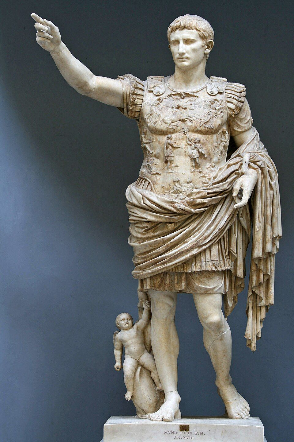 A marble statue of Augustus in armor, one arm raised